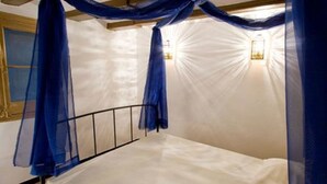 A room with a bed, a wooden headboard, and a white wall. - Palace Guesthouse (Barcelona)