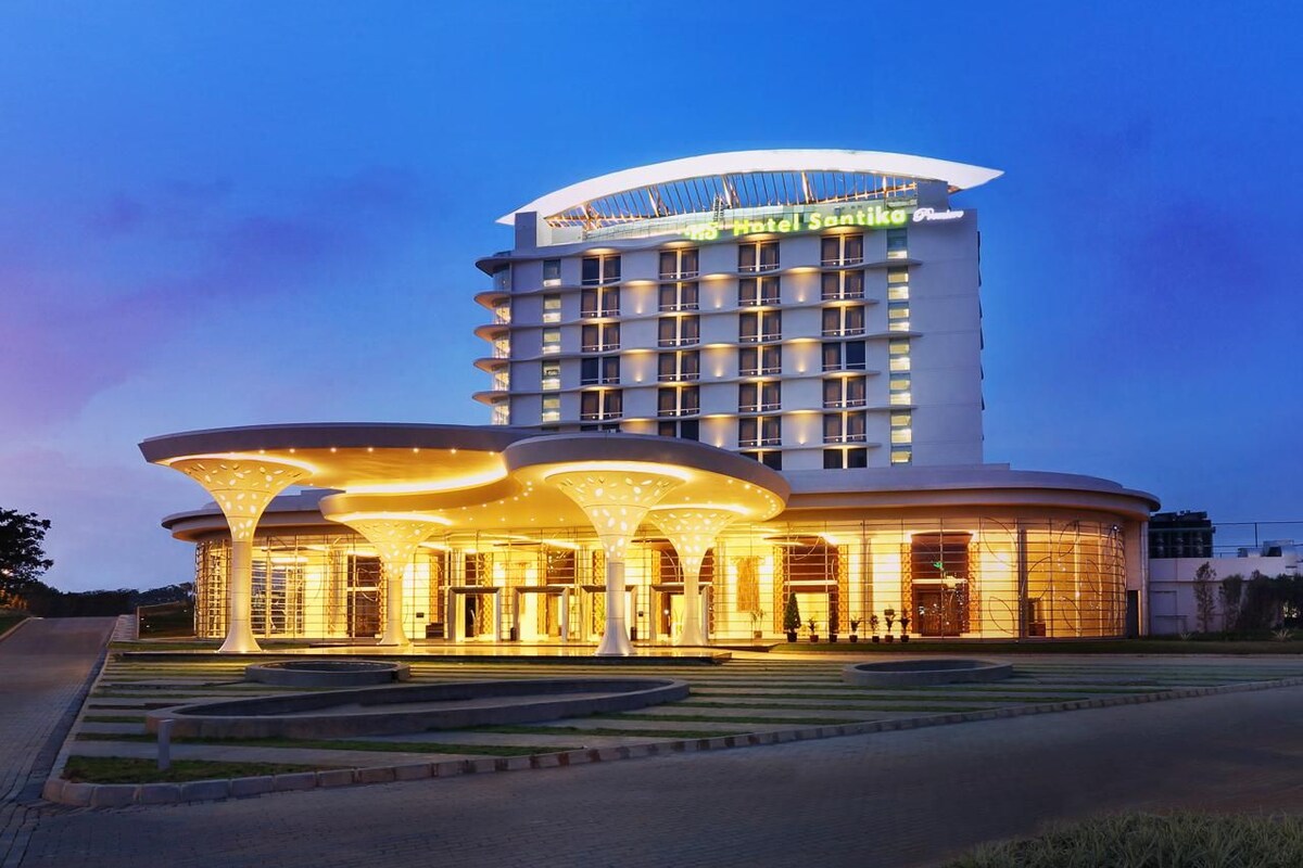 Ein Hotel mit modernem Design, das durch einen markanten, geschwungenen Eingang und mehrere Balkone besticht.