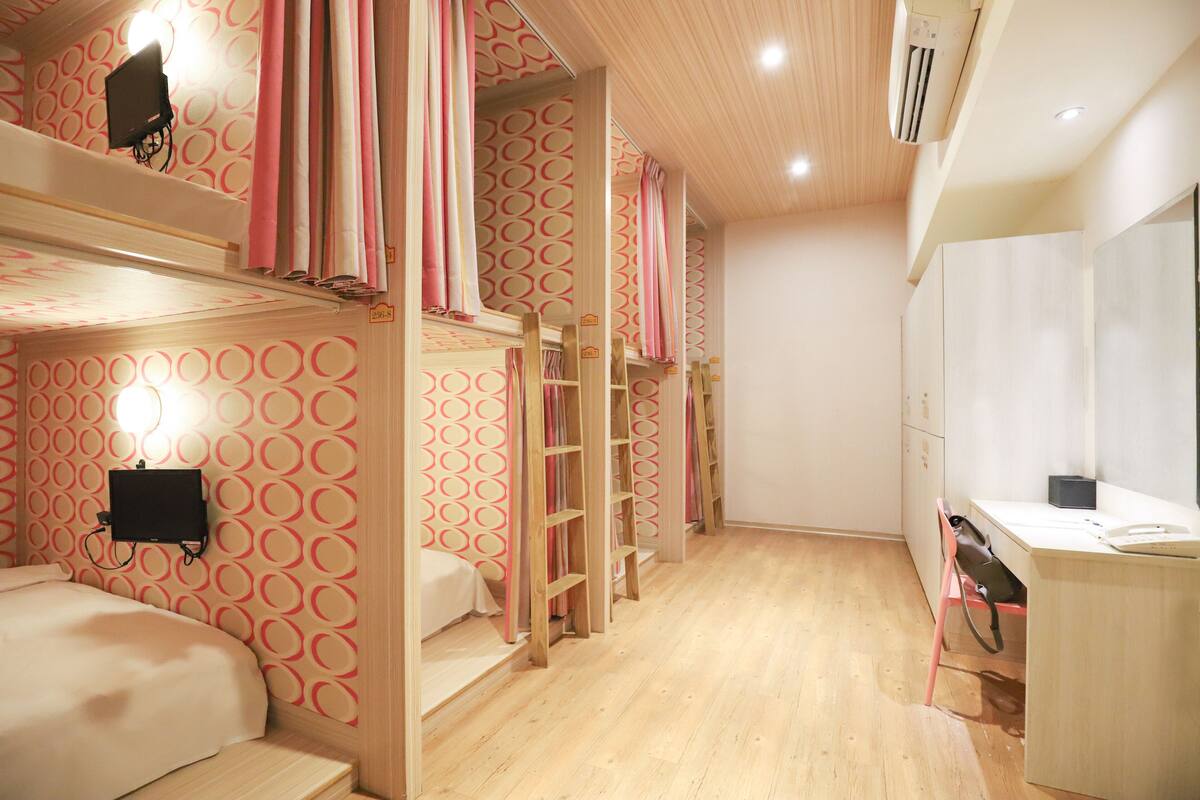 A room with bunk beds, a desk, and a chair.