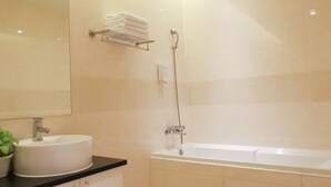 A bathroom with a sink, mirror, towel rack, and bathtub. - Anho Chew Hotel (Luodong)