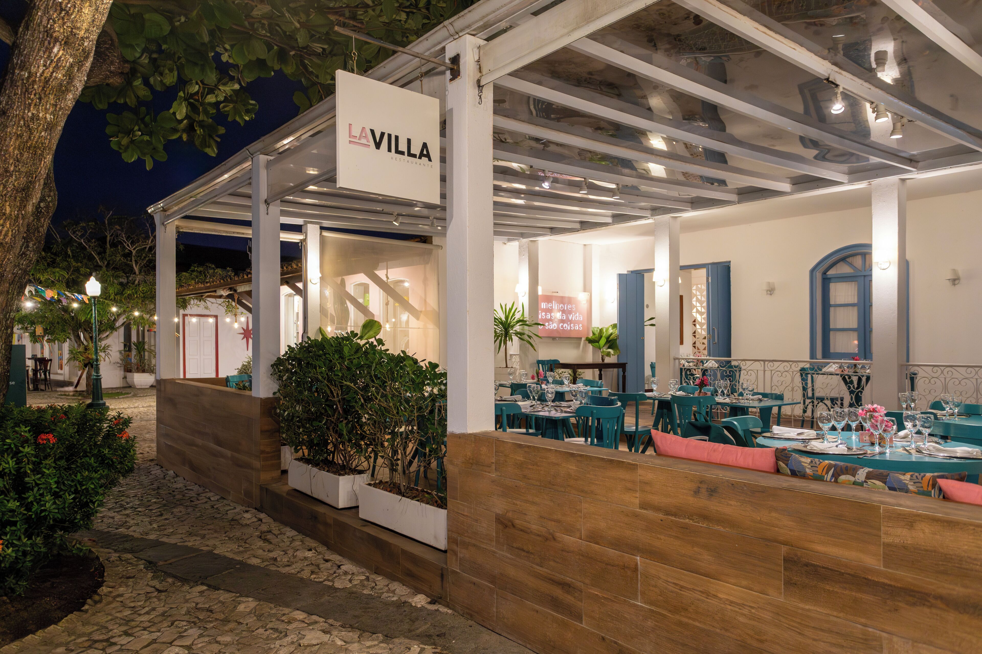 Un restaurant doté d’une terrasse, une enseigne indiquant « LA VILLA », et un chemin de pierres menant à l’entrée.