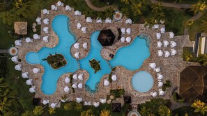 An aerial view of a resort with multiple swimming pools, lounge areas with umbrellas, and palm trees. - Sauipe Terra Resorts - All Inclusive (Mata de São João)