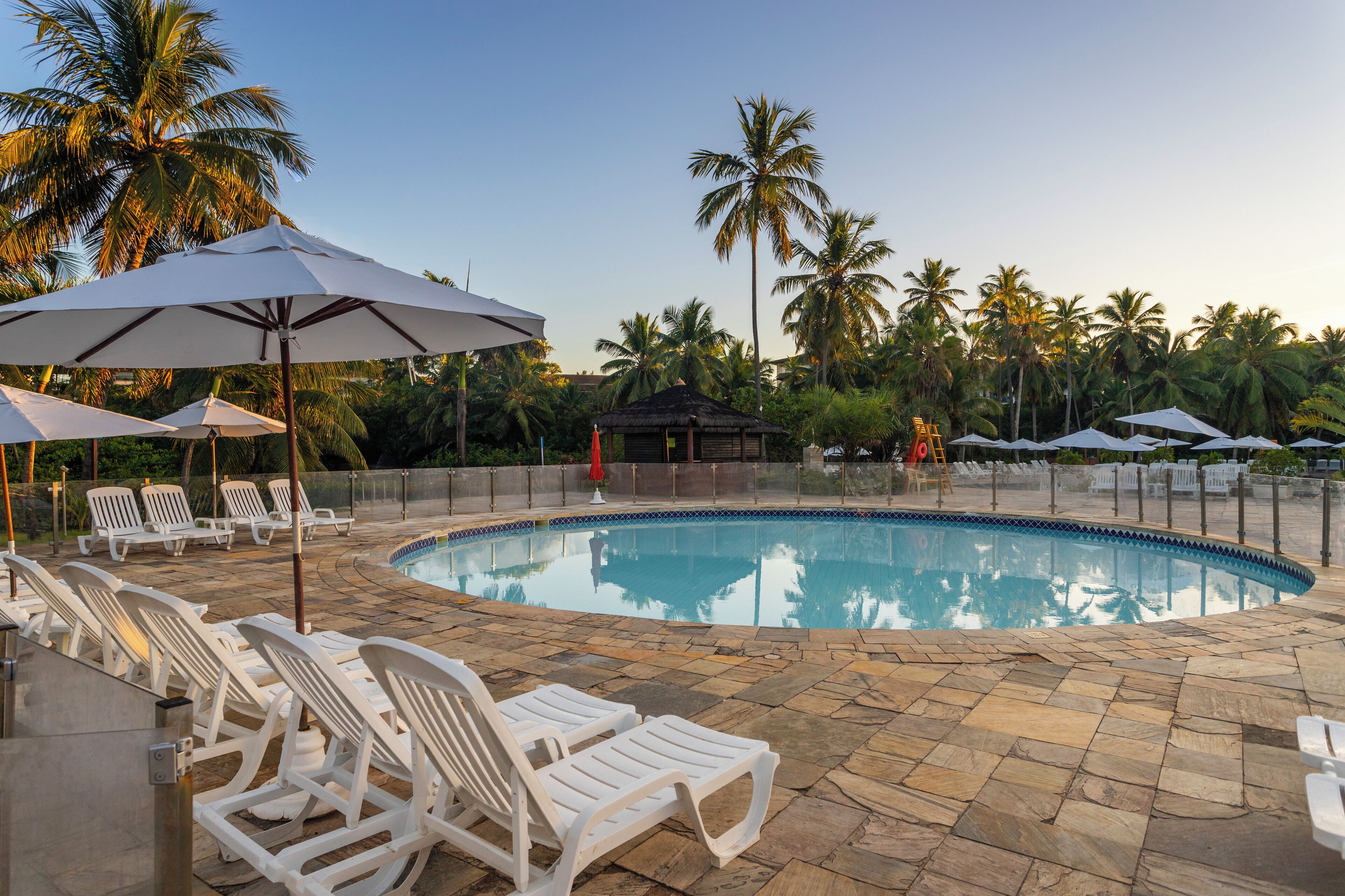 A pool area with lounge chairs and umbrellas.