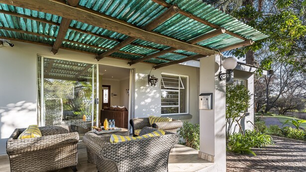 An outdoor patio with wicker furniture and a covered area. - The Haystack on Homestead (Sandton)