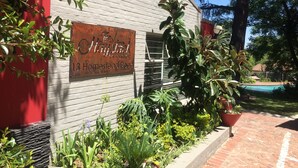 A rustic building with a sign reading "The Haystack on Homestead Road." - The Haystack on Homestead (Sandton)