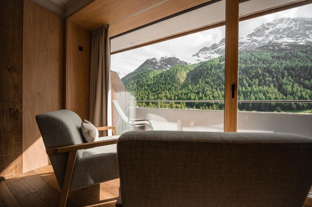 Ein Zimmer mit Blick auf eine Berglandschaft durch große Fenster.