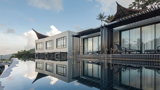 A modern hotel with a reflective pool, large windows, and a traditional roof design. - The Tarna Resort, Koh Tao (Koh Tao)