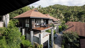 A two-story house with a balcony, surrounded by lush greenery and palm trees. - The Tarna Resort, Koh Tao (Koh Tao)