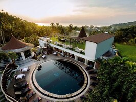 Ein Resort mit Pool, Sitzgelegenheiten im Freien und Blick auf den Ozean.
