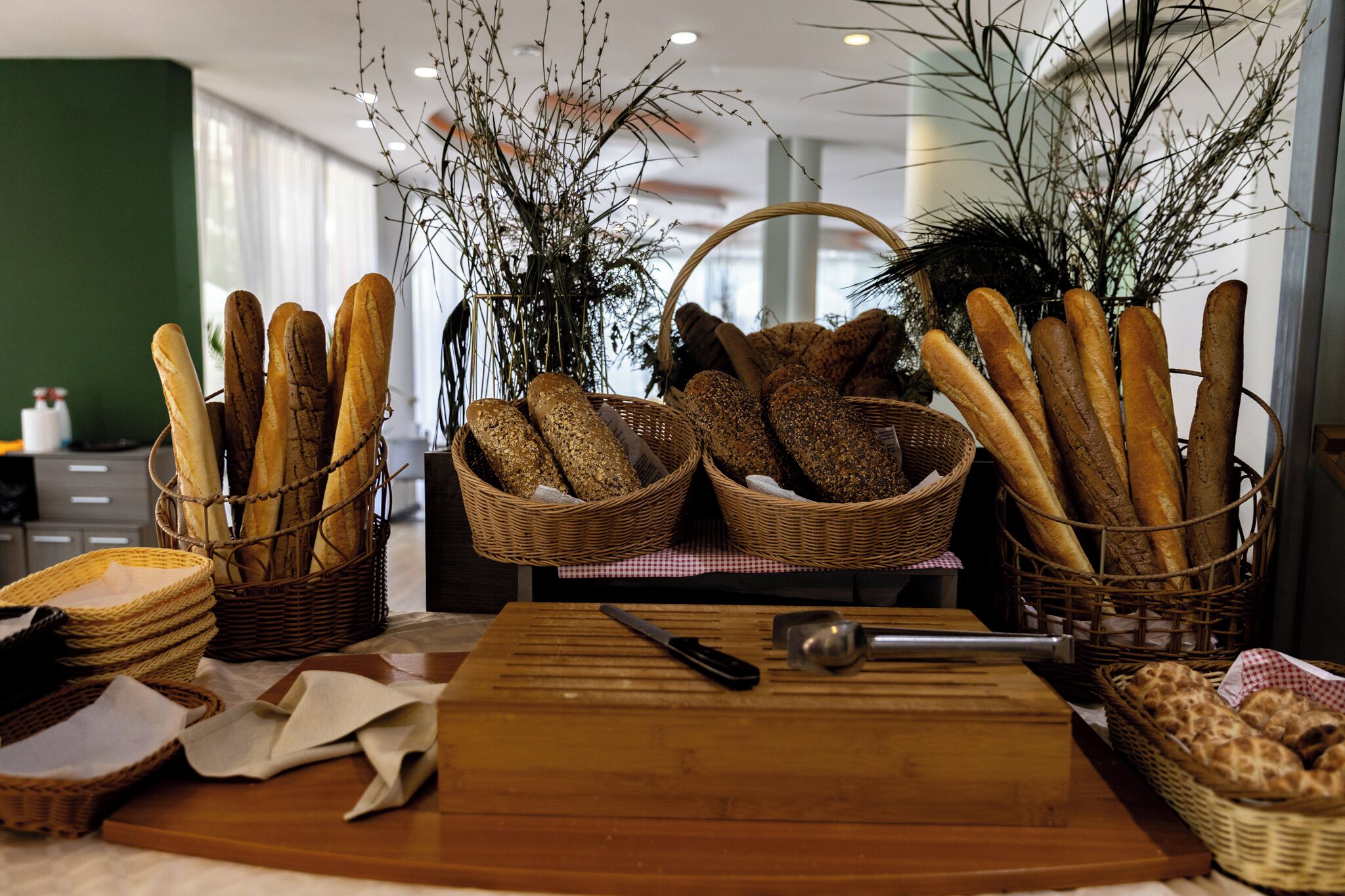 Un taulell amb cistades de baguettes, una taula de tallar i un ganivet.