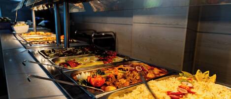 A buffet with various food options including rice, meats, and vegetables.