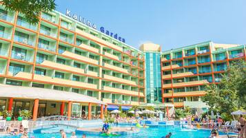 A hotel with multiple swimming pools, outdoor seating areas, and a large building with balconies.