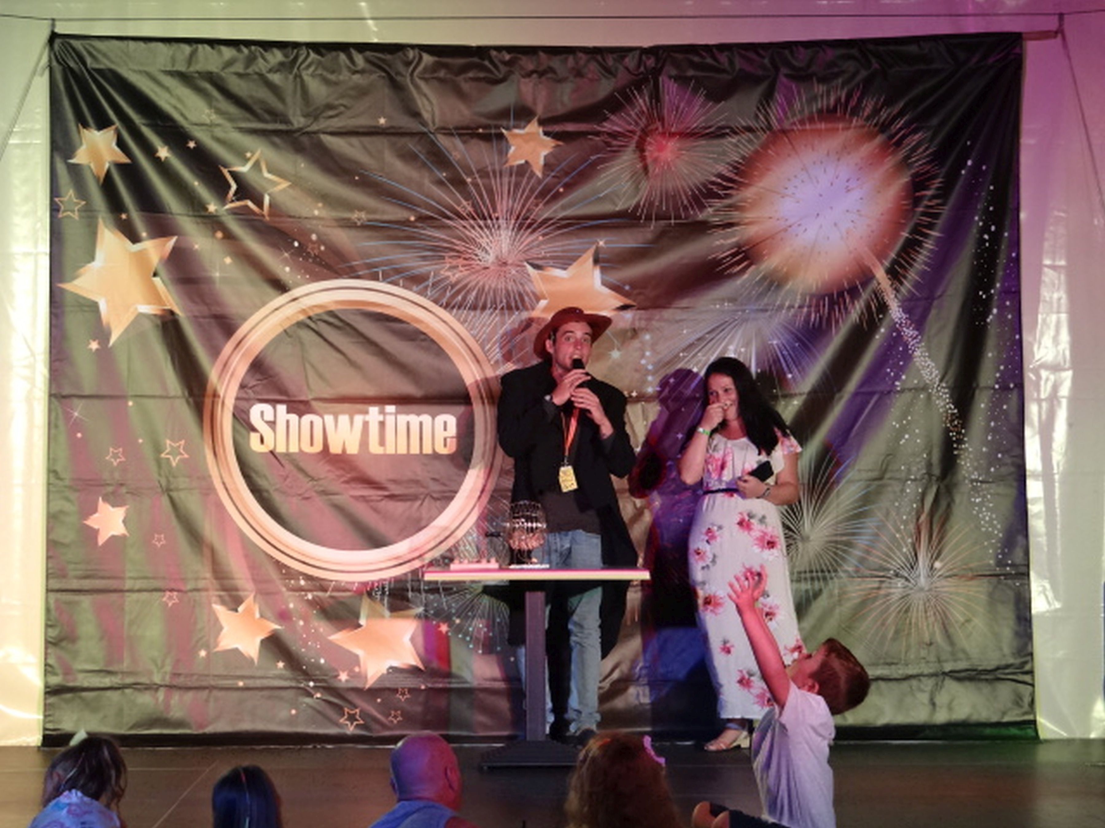 Un escenario con un fondo que muestra estrellas y fuegos artificiales, y la palabra 'Showtime' mostrada en grande.