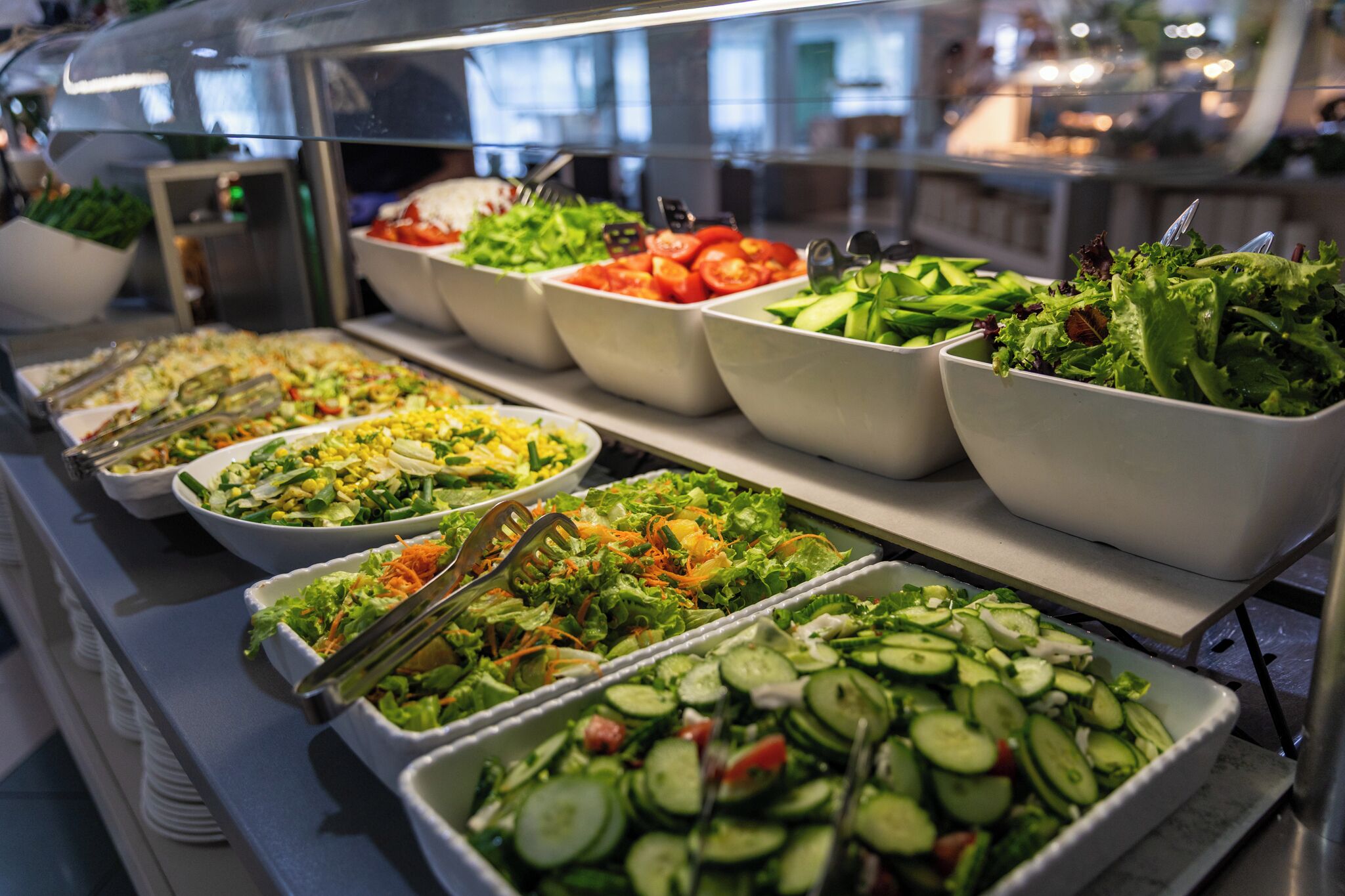 A buffet with various salads and vegetables.