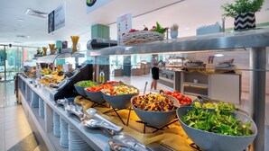 A buffet with various salads and dishes, a sign indicating 'Salads', and a potted plant on the counter. - MPM Kalina Garden Hotel (Sunny Beach)