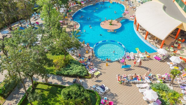 A large outdoor swimming pool surrounded by lounge chairs and umbrellas, with a building in the background. - MPM Kalina Garden Hotel (Sunny Beach)
