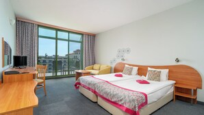 A hotel room with a large bed, a desk, a chair, and a sofa. - MPM Kalina Garden Hotel (Sunny Beach)