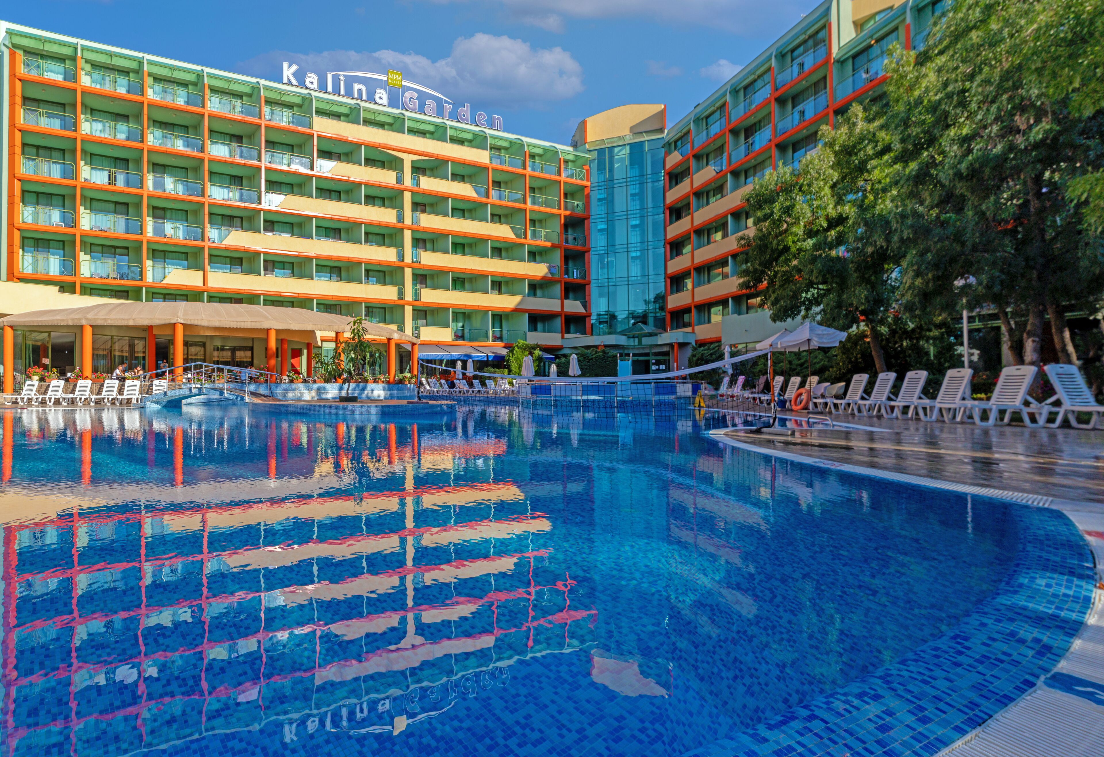 A hotel with a swimming pool, multiple balconies, and a sign reading "Kalina Garden".
