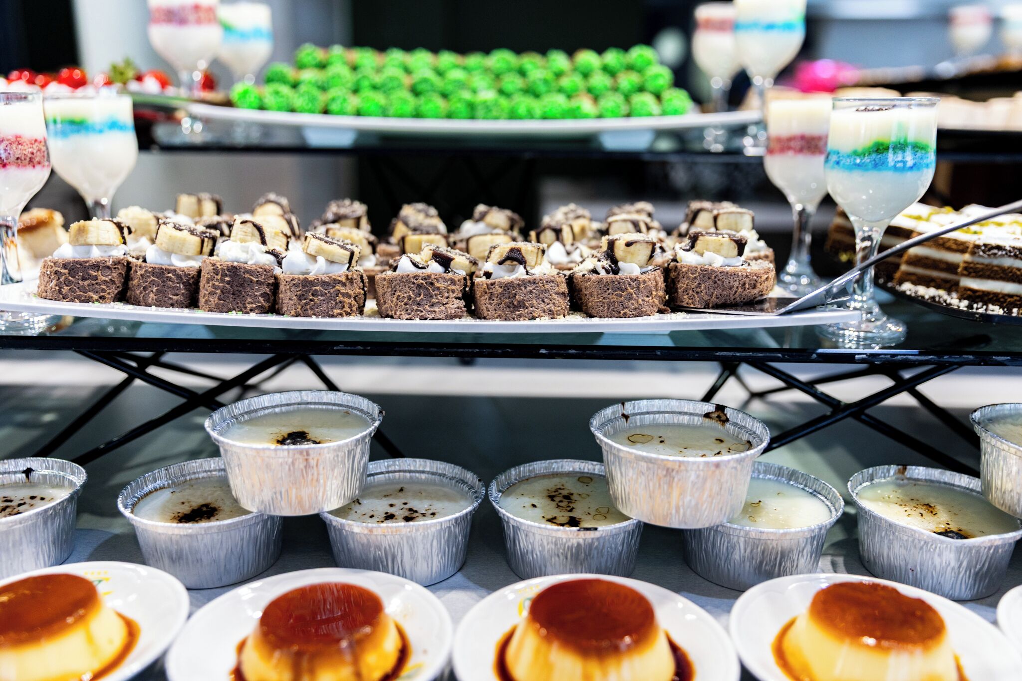 A dessert buffet with various cakes and puddings.
