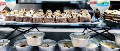 A dessert buffet with various cakes and puddings.