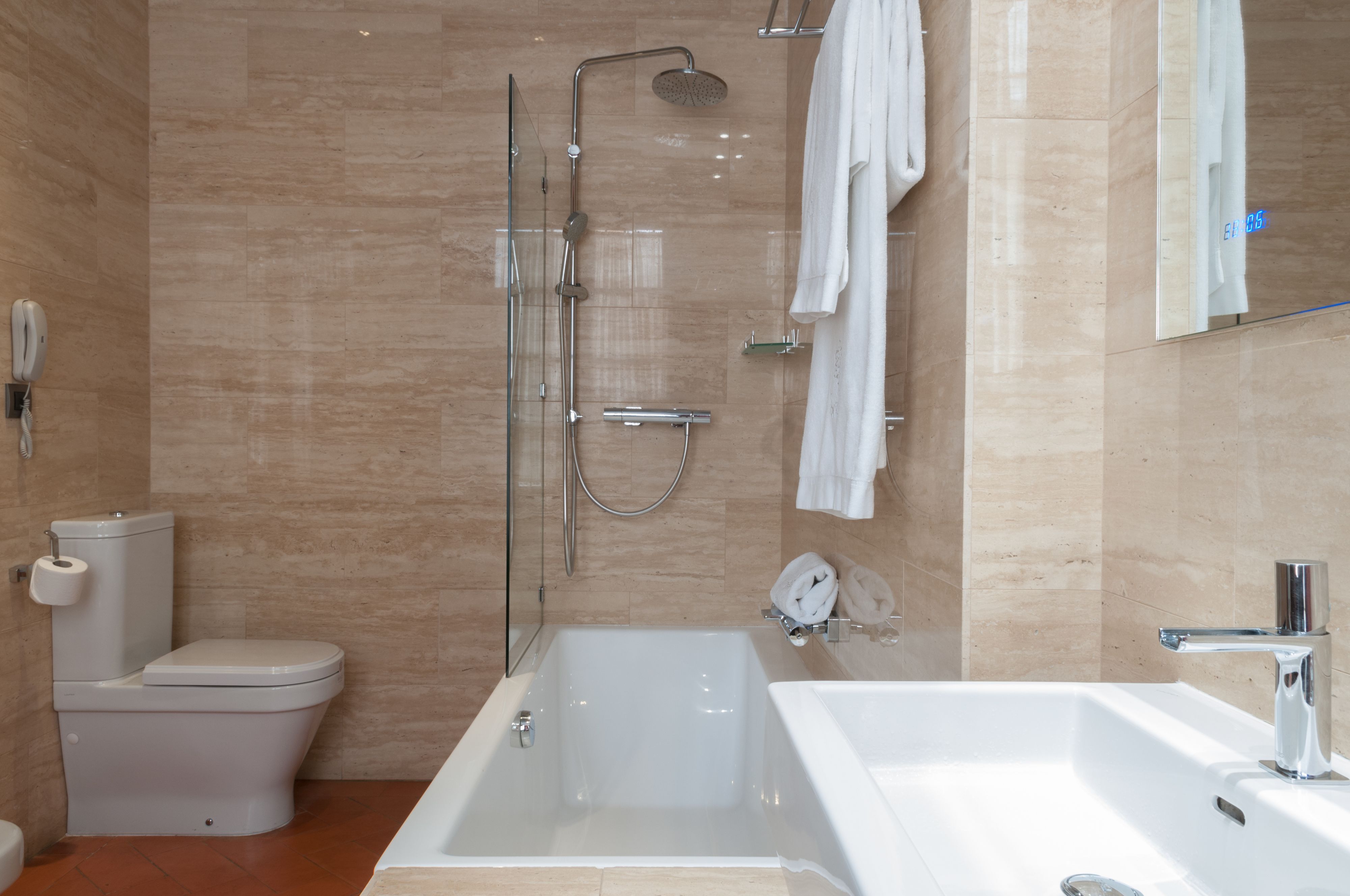 Une salle de bain moderne équipée de toilettes, d’une douche et d’une baignoire.