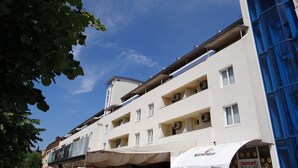 Un hotel de varios pisos, con balcones y un cielo azul despejado.