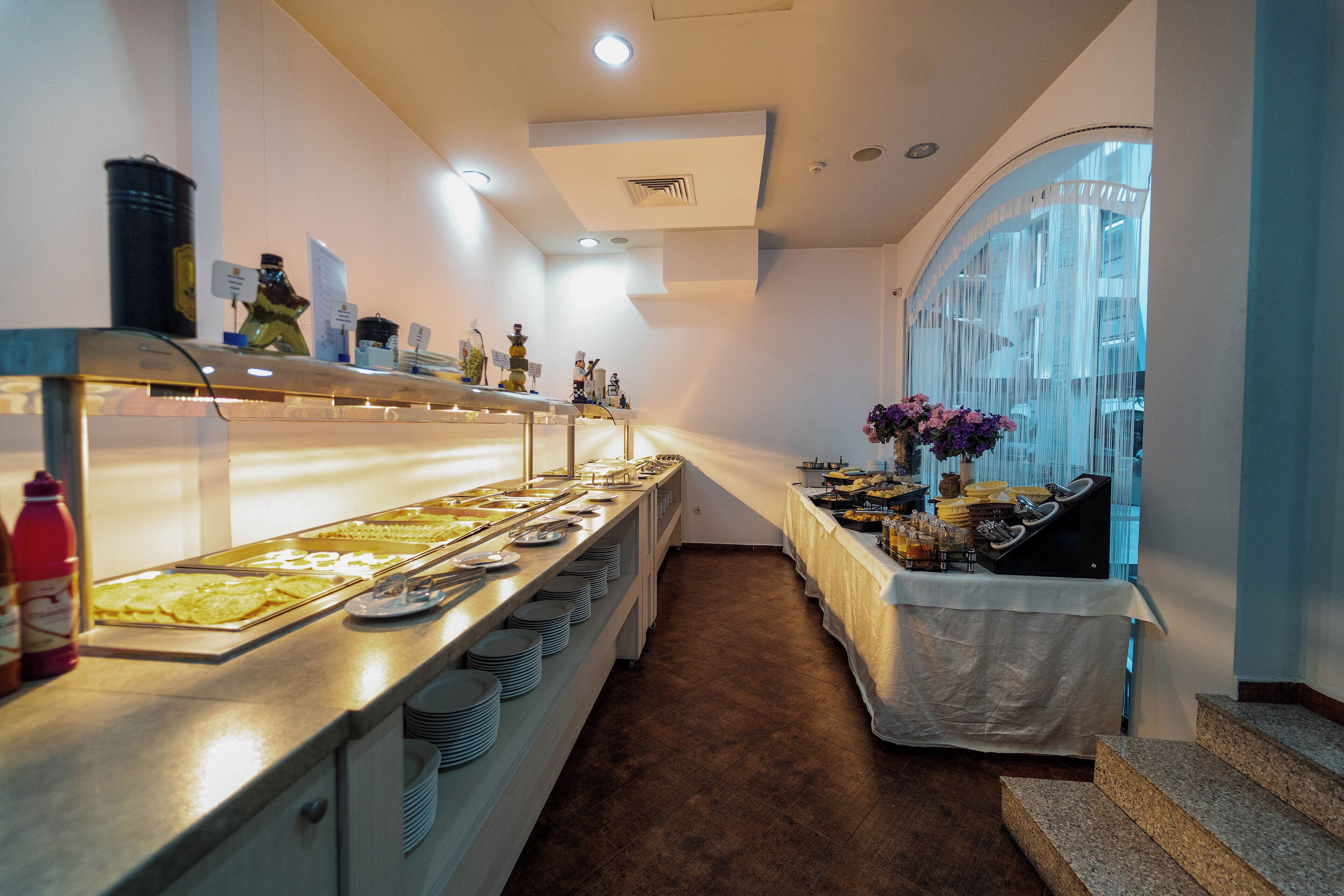A buffet setup with various food items and condiments.