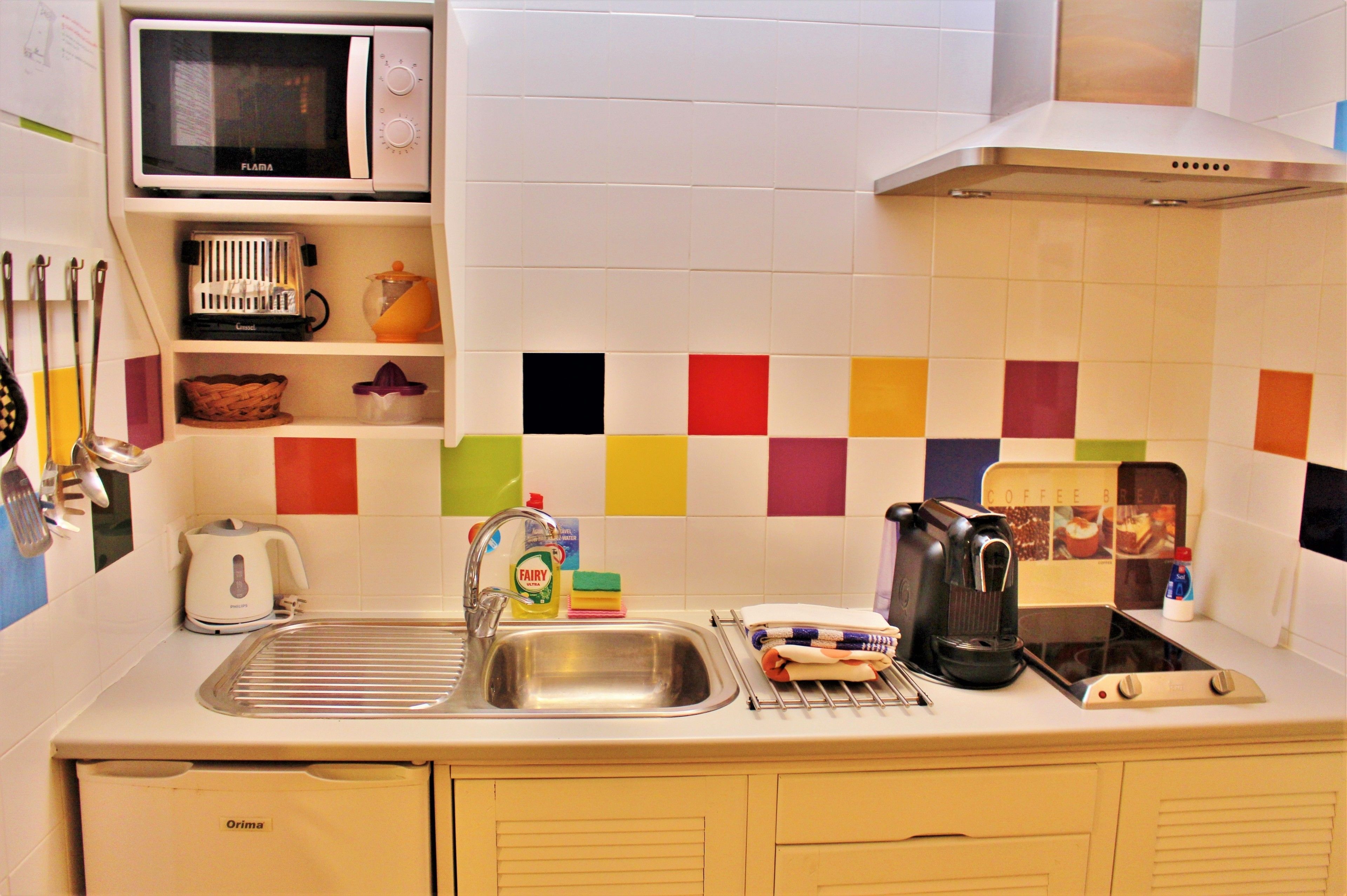A kitchen with a microwave, sink, and various appliances.