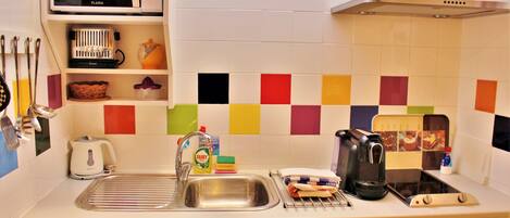 A kitchen with a microwave, sink, and various appliances.