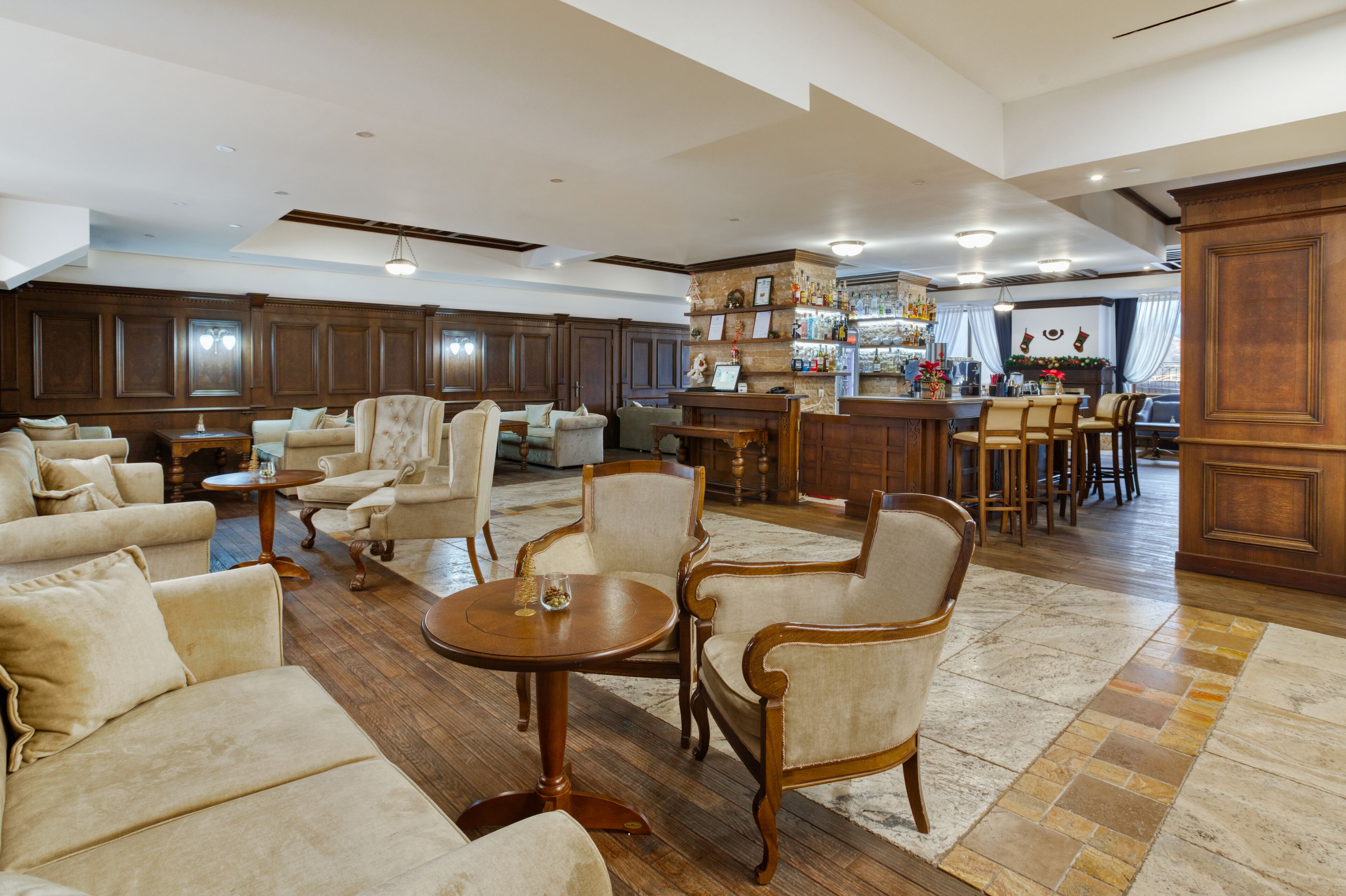 Amplia sala de estar con diversas opciones de asientos, una zona de bar y una cocina a la vista.