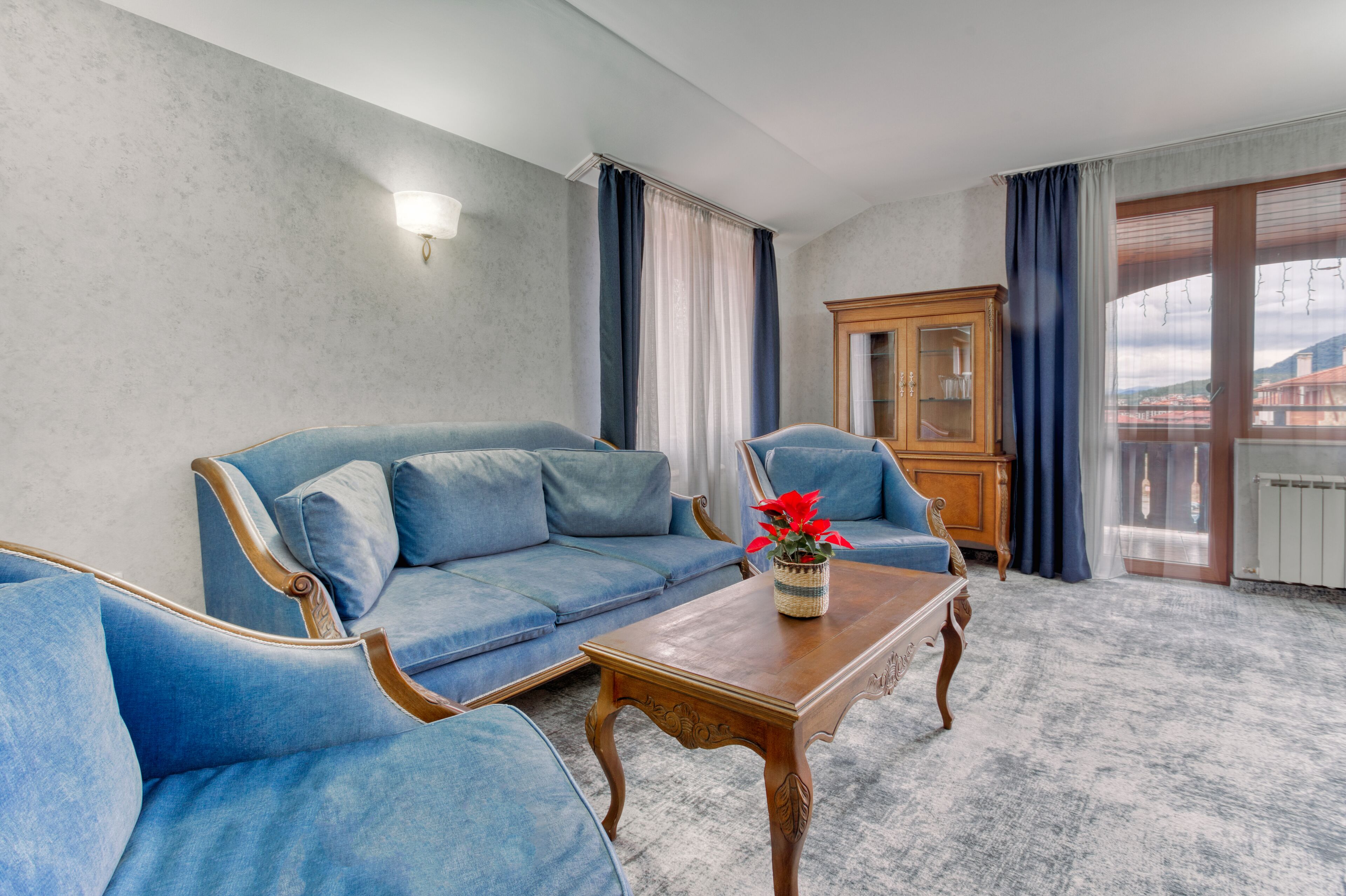 A living room with a blue sofa, a wooden coffee table, and a cabinet.