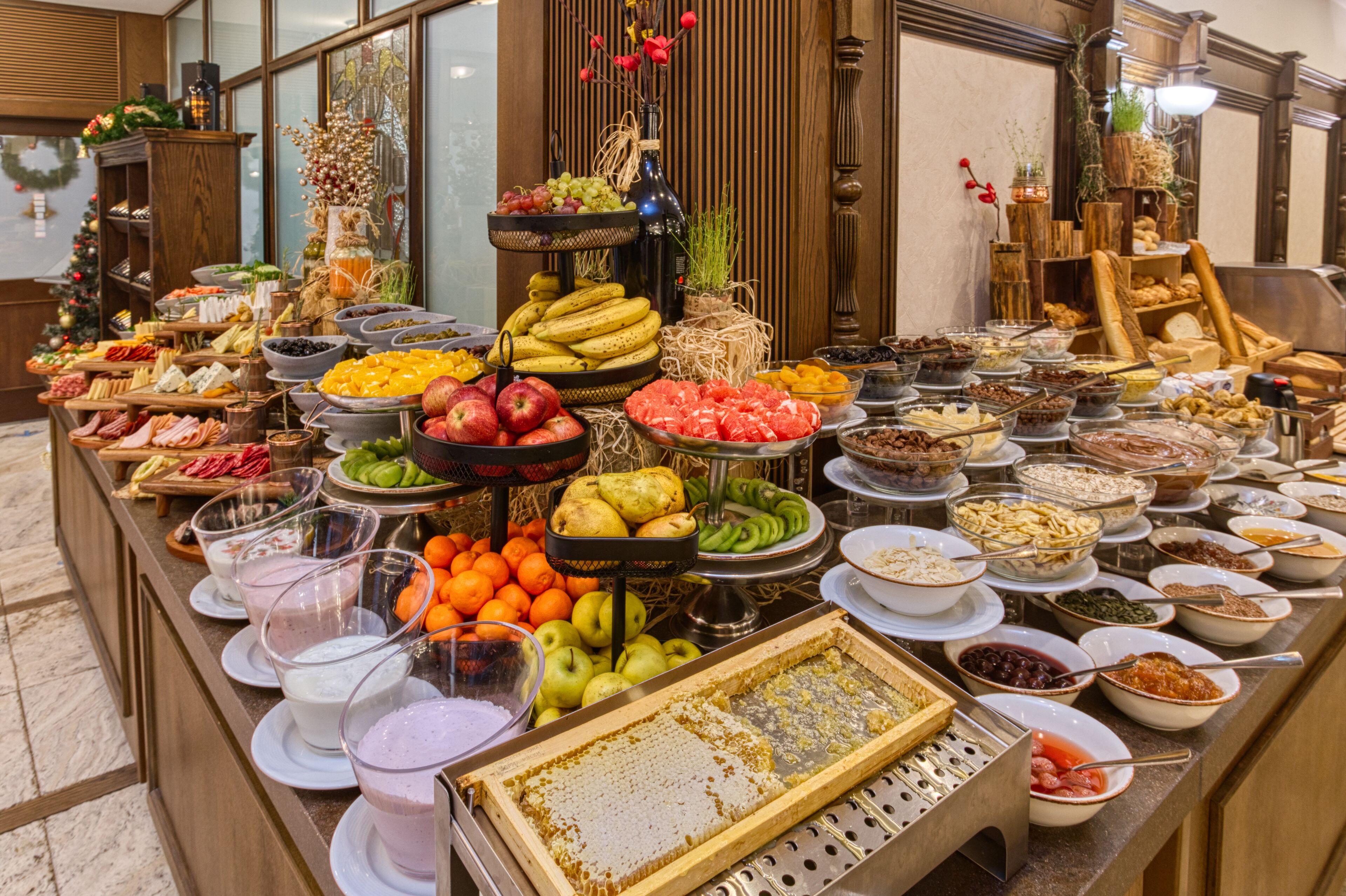 Un buffet proposant une variété de plats et de boissons, notamment des fruits, des fromages et des salades.