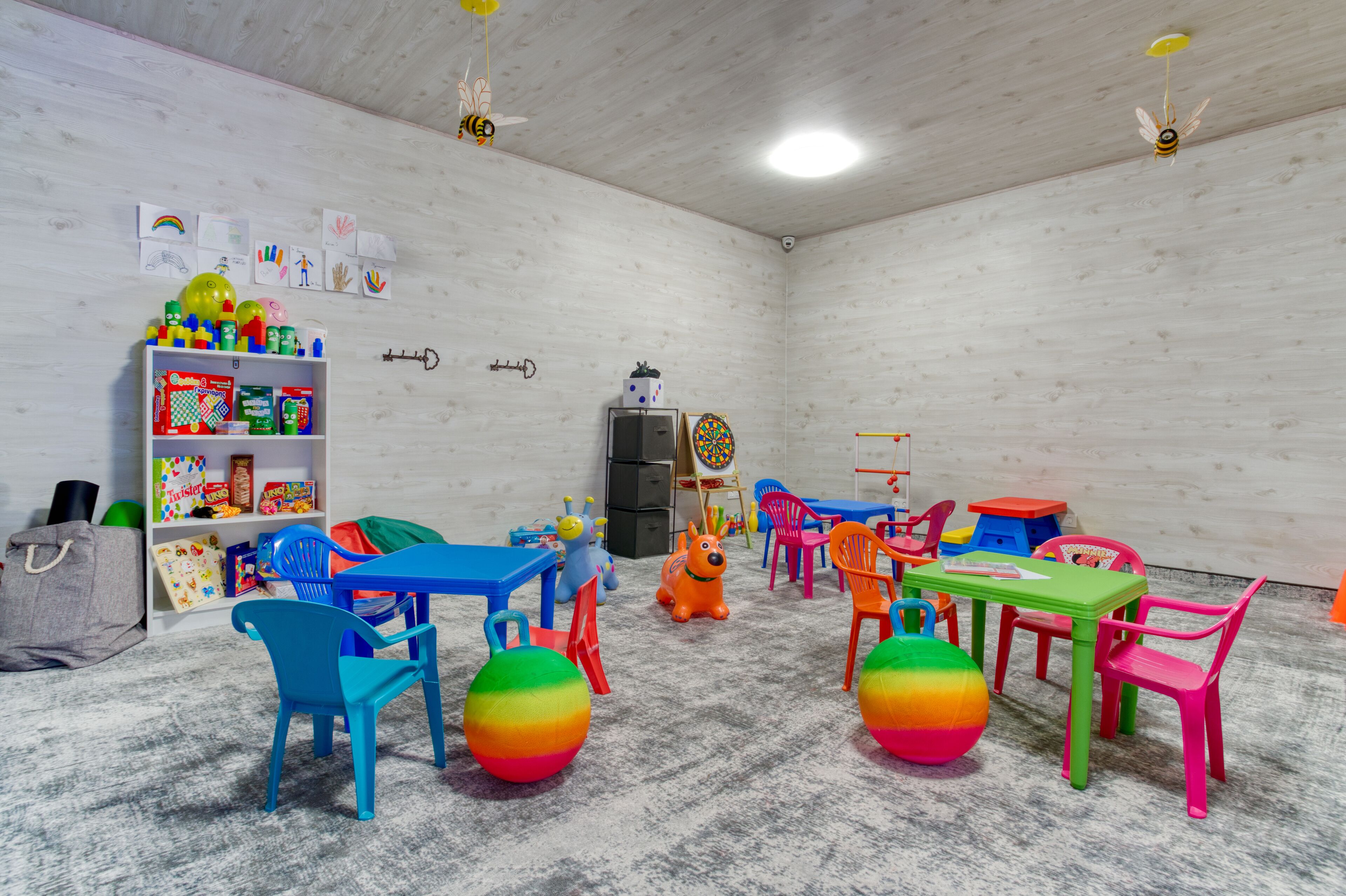 A children's playroom with colorful furniture, toys, and educational materials.