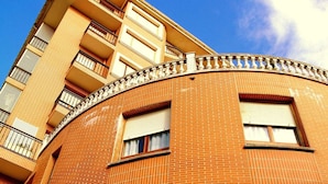 A multi-story building with a curved facade, balconies, and large windows. - Pensión La Salve (Bilbao)