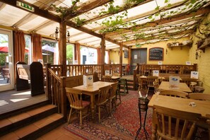 A restaurant with wooden tables and chairs, a red patterned carpet, and a menu board on the wall. - Lifeboat Inn (Hunstanton)