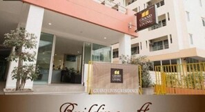 A Grand Living Residence building entrance with a glass facade, a reception area, and a gated entrance. - Grand Living Residence (Chiang Mai)