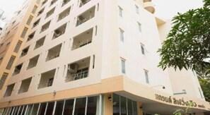 A multi-story building with balconies and a sign in a foreign script. - Grand Living Residence (Chiang Mai)