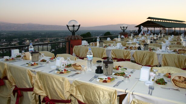 Una mesa de banquete dispuesta para una comida, con una vista panorámica al fondo.