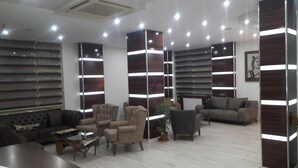 Una sala de estar moderna con sofás, sillones y una mesa de centro.