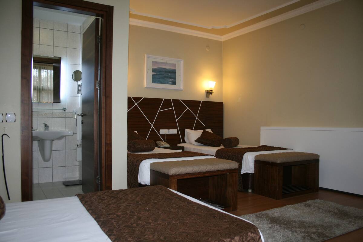 Habitación de hotel con dos camas, un baño y vista al mar.