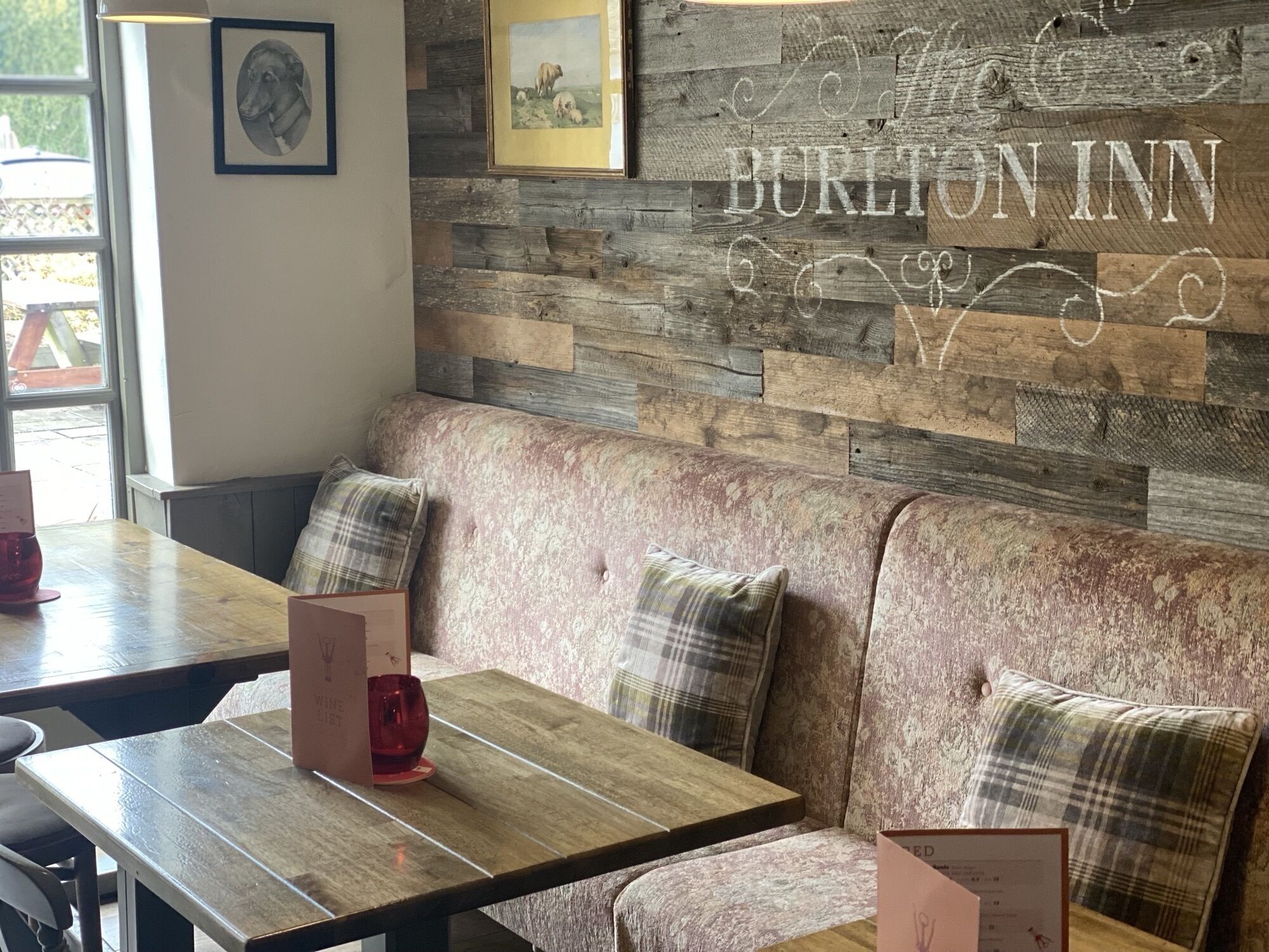 A cozy seating area with a wooden wall and a sign reading "BURTON INN".