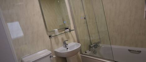 A bathroom with a toilet, sink, and bathtub.