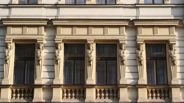 Fachada de edifício com elementos arquitetônicos clássicos, incluindo colunas e estátuas.