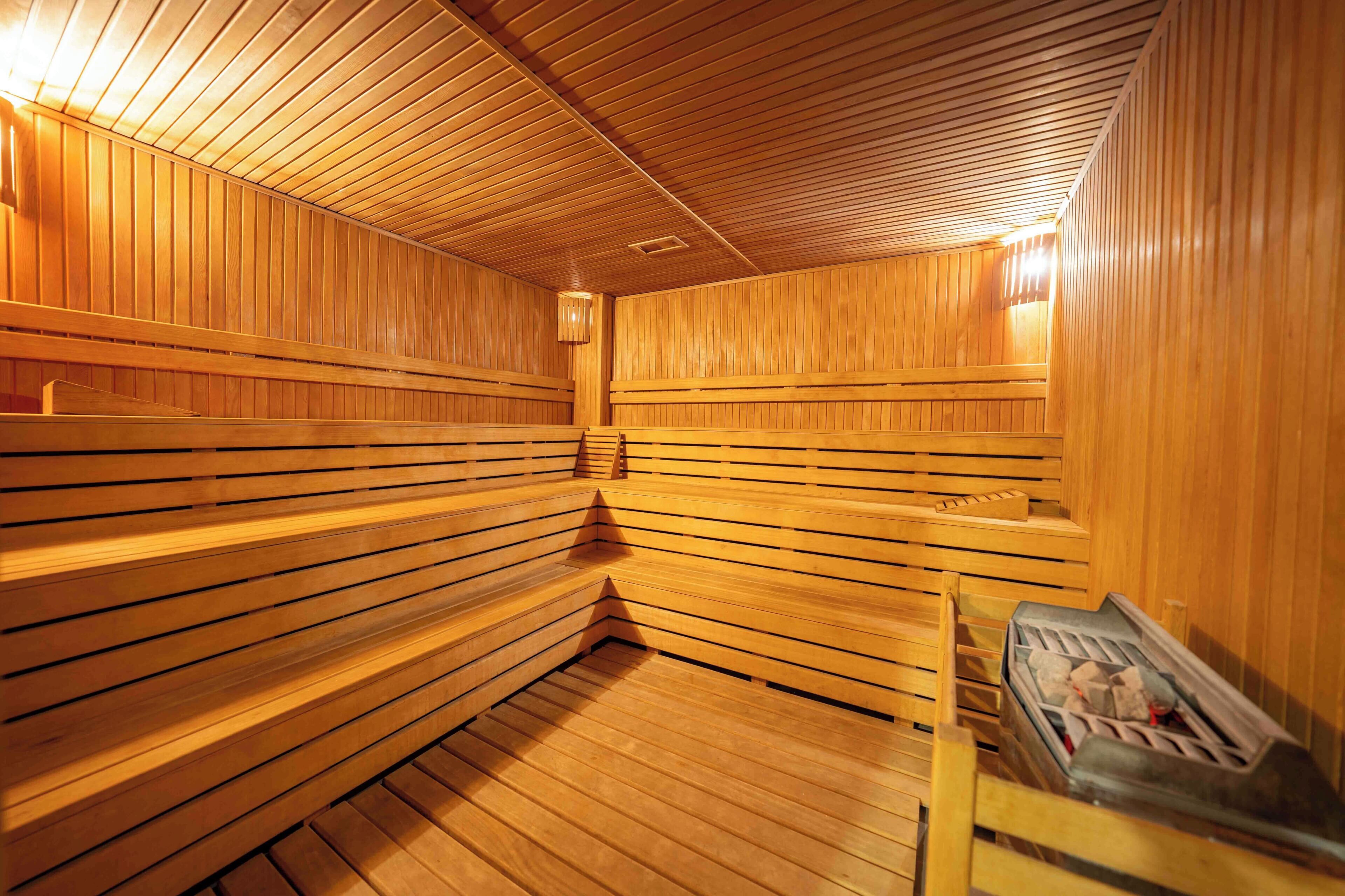A sauna with wooden benches and a bench with a towel.