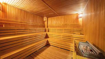 A sauna with wooden benches and a bench with a towel.