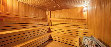 A sauna with wooden benches and a bench with a towel.