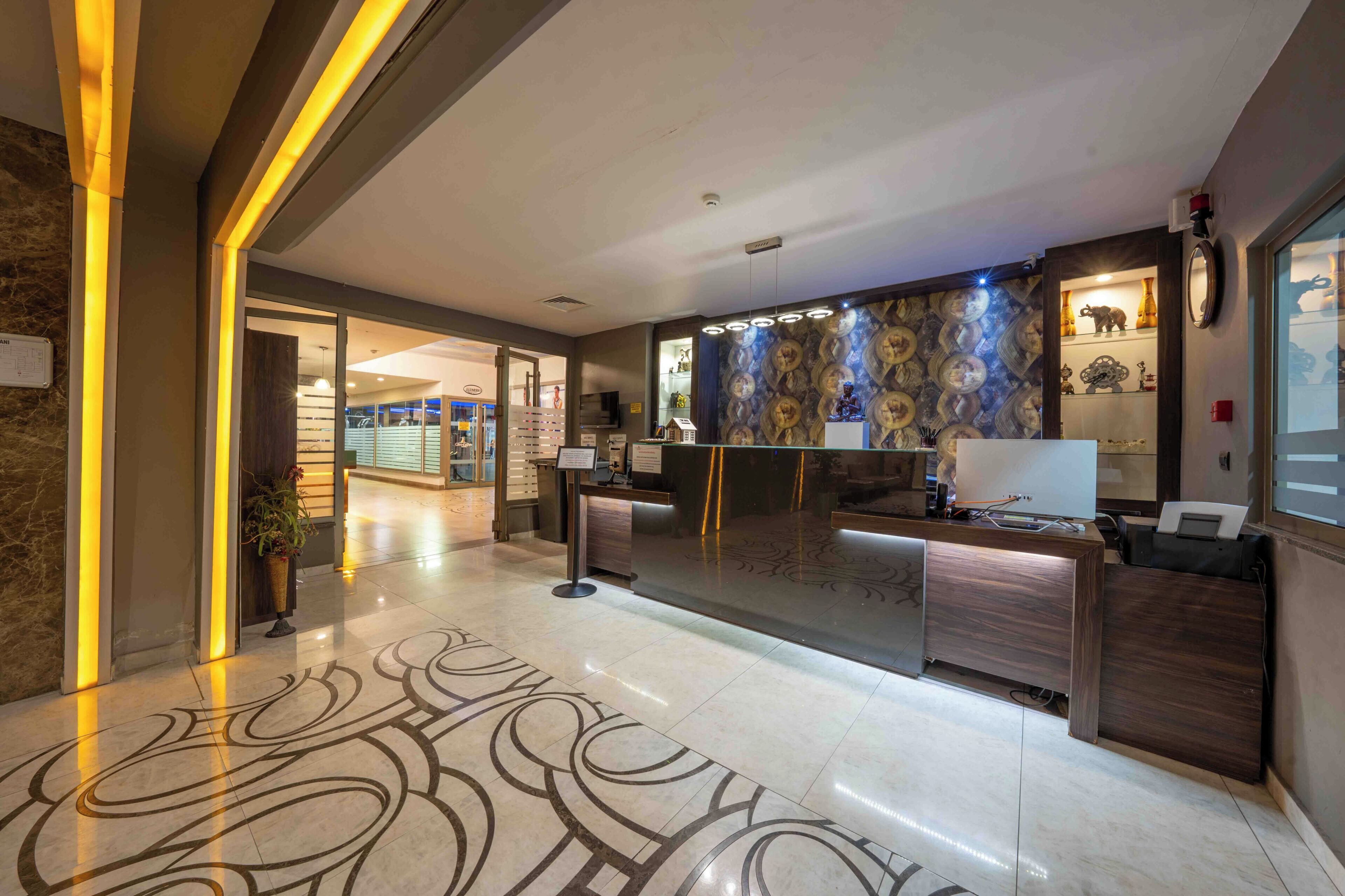 A modern reception area with a marble floor, a reception desk, and a patterned wall.