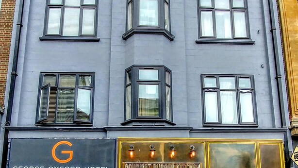 A multi-story hotel with a sign for the George Oxford Hotel and Gourmet Burger Kitchen. - George Oxford Hotel (Oxford)