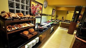 Un espace buffet où diverses préparations culinaires sont présentées sur des étagères et des comptoirs.