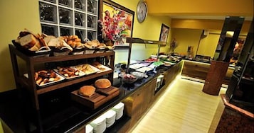 Un área de bufé con diversos alimentos expuestos en estantes y mostradores.